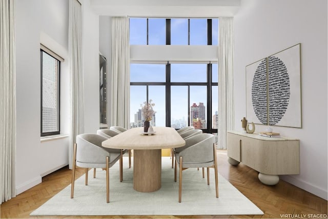 dining room with a view of city, a high ceiling, and baseboards