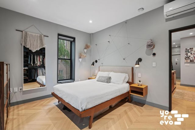 bedroom featuring light parquet flooring and an AC wall unit