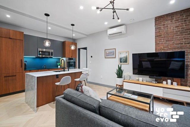 living room with an inviting chandelier, sink, an AC wall unit, and light parquet flooring