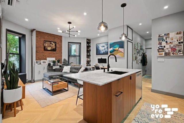 kitchen featuring sink, a breakfast bar area, dishwasher, light parquet flooring, and a kitchen island with sink