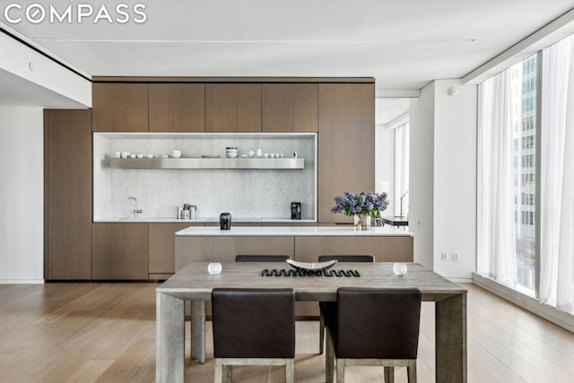 interior space featuring a kitchen breakfast bar, light hardwood / wood-style flooring, and backsplash