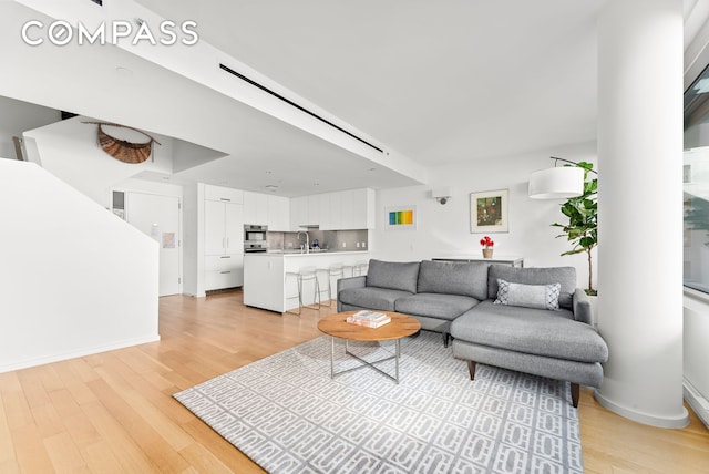 living area with light wood-style flooring and baseboards