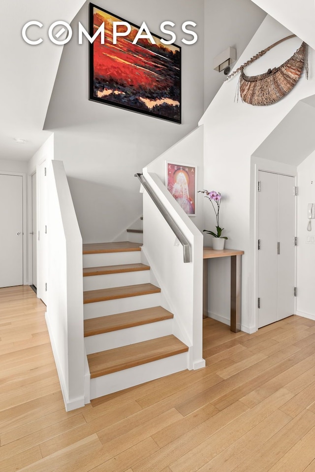 staircase featuring baseboards and wood finished floors