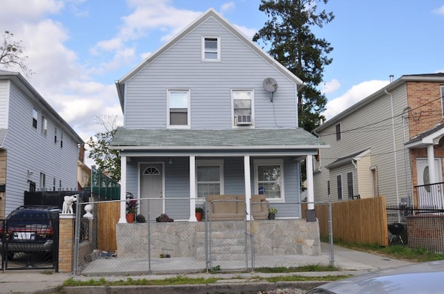 american foursquare style home with a porch, a gate, and a fenced front yard