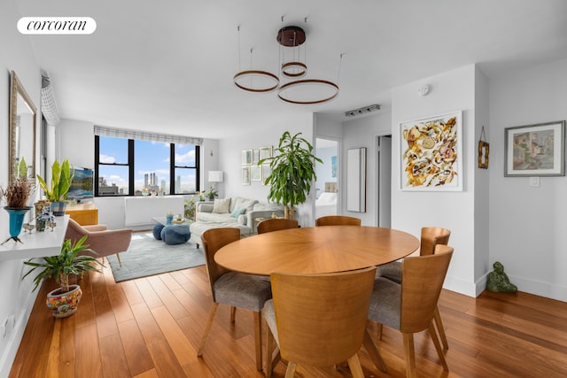 dining room with hardwood / wood-style floors and a notable chandelier