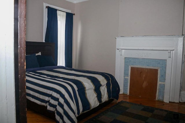 bedroom featuring ornamental molding and hardwood / wood-style flooring