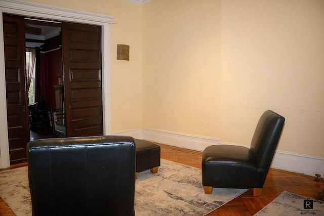 sitting room featuring parquet flooring and crown molding