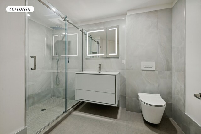 full bath with a shower stall, vanity, toilet, tile walls, and tile patterned floors