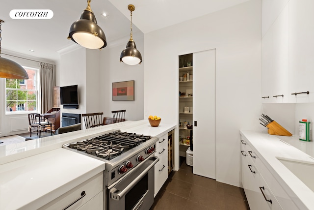 kitchen featuring visible vents, high end range, and white cabinetry