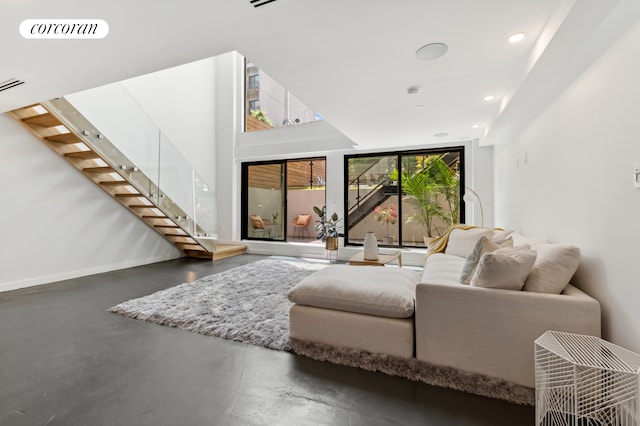 living room featuring concrete flooring, recessed lighting, visible vents, baseboards, and stairway