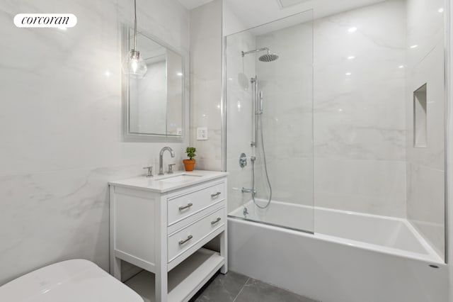 full bathroom featuring toilet, tiled shower / bath combo, tile walls, and vanity