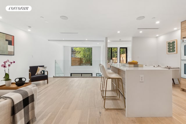 kitchen featuring open floor plan, light wood finished floors, a kitchen island, and visible vents