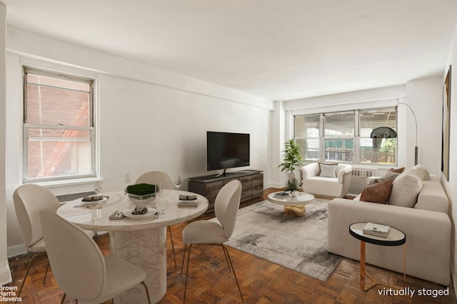 living room with a healthy amount of sunlight and dark parquet flooring