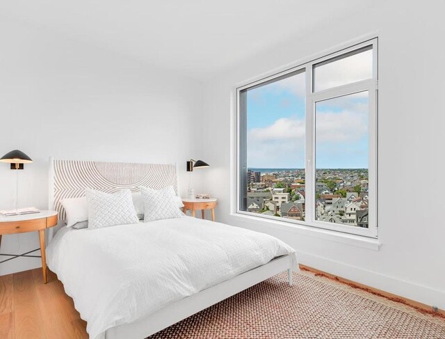 bedroom with wood-type flooring and multiple windows