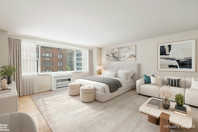 bedroom featuring heating unit and wood finished floors