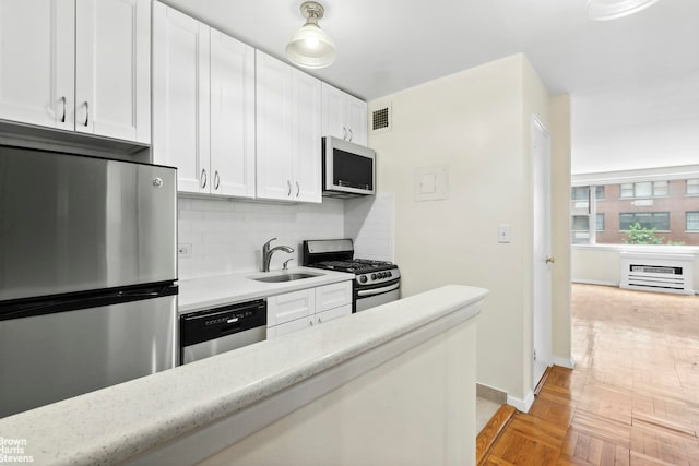 kitchen with visible vents, backsplash, light countertops, stainless steel appliances, and a sink