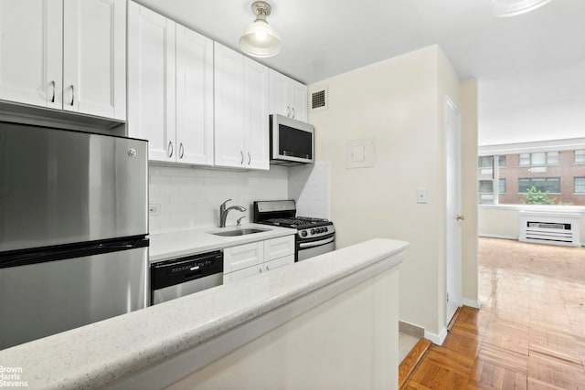 139 E 33rd St Unit 2C, New York City, NY 10016 - kitchen featuring stainless steel appliances, light countertops, white cabinets, and tasteful backsplash