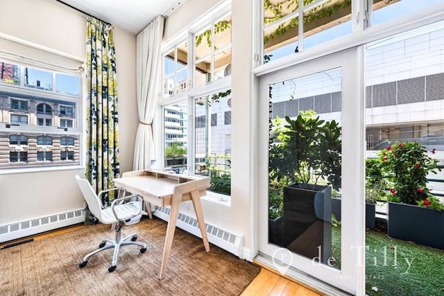 interior space featuring a baseboard heating unit and hardwood / wood-style floors