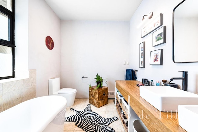 bathroom featuring toilet, a bath, vanity, and tile patterned flooring