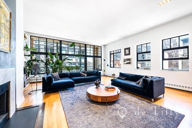 living room featuring a baseboard heating unit, a wealth of natural light, and hardwood / wood-style floors