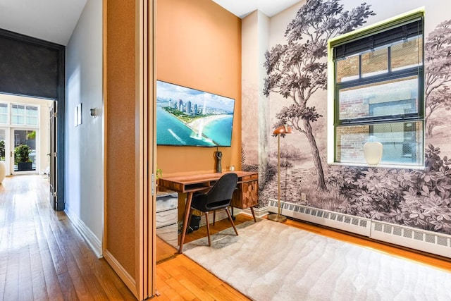 office featuring a baseboard heating unit and wood-type flooring