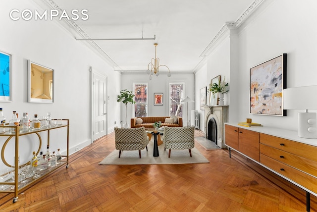 dining room featuring crown molding, a fireplace with flush hearth, baseboards, and a chandelier