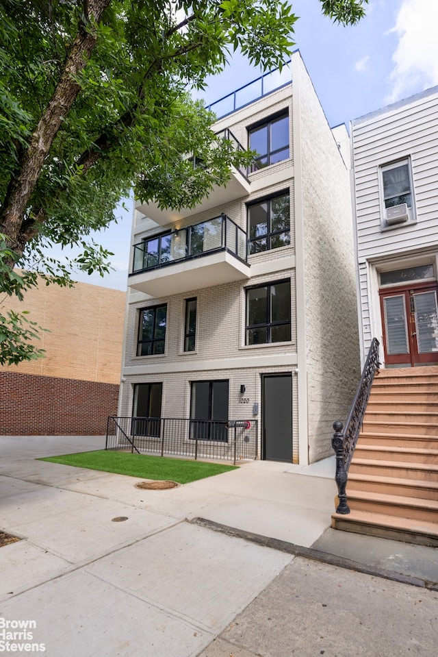 view of front of house with fence, stairway, and stucco siding