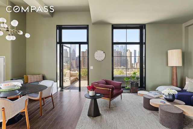 living area featuring a wealth of natural light, a wall of windows, a view of city, and wood-type flooring