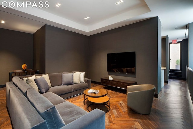 living room with a tray ceiling and parquet floors