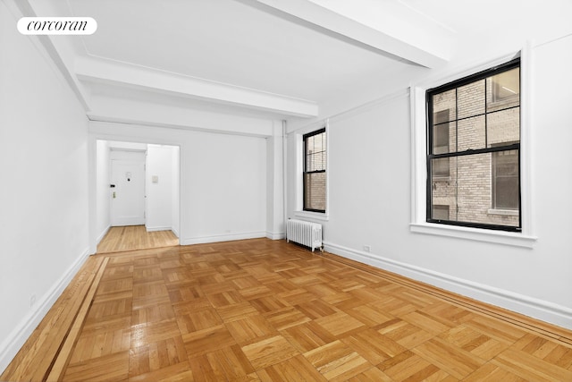 empty room with radiator heating unit and baseboards