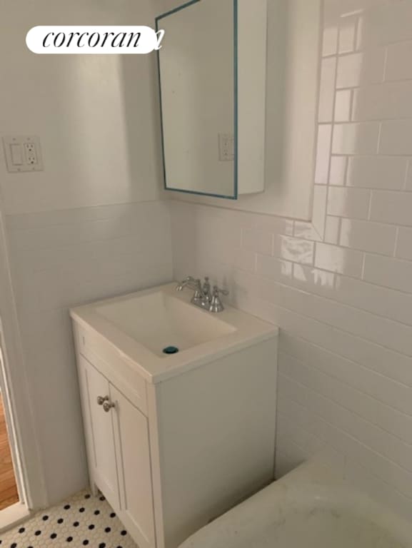 bathroom with vanity, tile patterned flooring, and tile walls