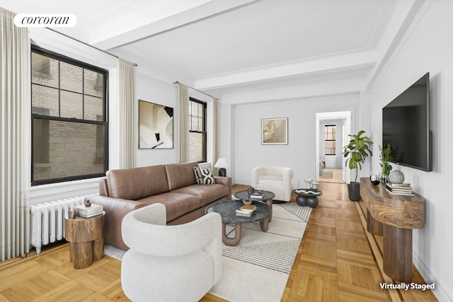 living room featuring beam ceiling, light parquet flooring, and radiator heating unit