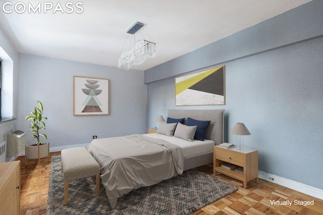 bedroom featuring parquet flooring and a notable chandelier