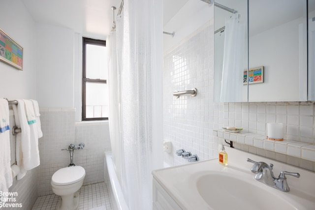 full bathroom with shower / tub combo with curtain, tile patterned floors, toilet, tile walls, and vanity