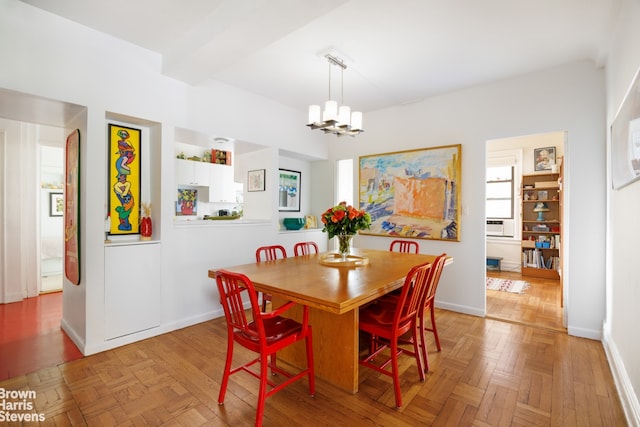 dining area featuring beamed ceiling, a chandelier, and light parquet flooring