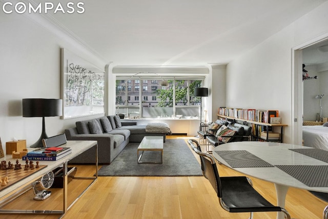 living room featuring wood-type flooring and ornamental molding