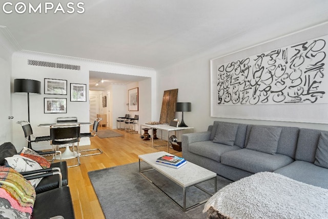 living room featuring wood-type flooring and crown molding