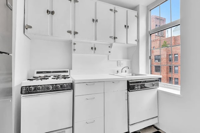 405 W 23rd St Unit 16I, New York City, NY 10011 - kitchen featuring white appliances, a sink, light countertops, and white cabinetry