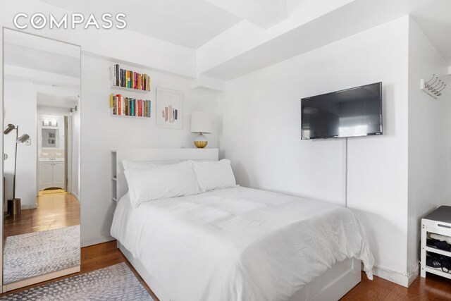 bedroom with baseboards and wood finished floors