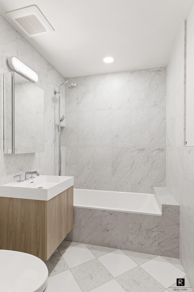 bathroom featuring visible vents, toilet, a combined bath / shower with marble appearance, marble finish floor, and vanity