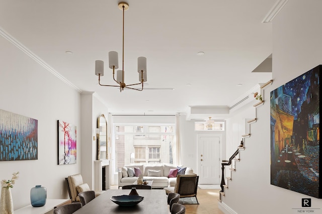 living area featuring a notable chandelier, light wood finished floors, baseboards, ornamental molding, and stairway