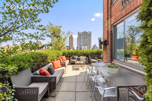 view of patio / terrace with a view of city, outdoor dining area, and outdoor lounge area