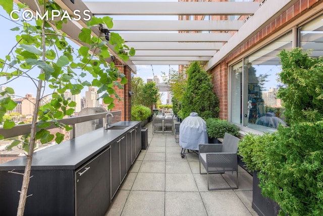 view of patio / terrace with a view of city, a pergola, and a sink