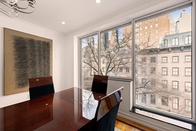 dining room featuring ornamental molding, hardwood / wood-style floors, and a notable chandelier