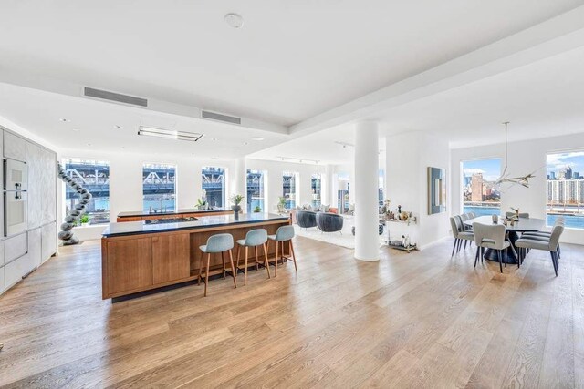 kitchen with plenty of natural light, pendant lighting, a notable chandelier, and light hardwood / wood-style flooring