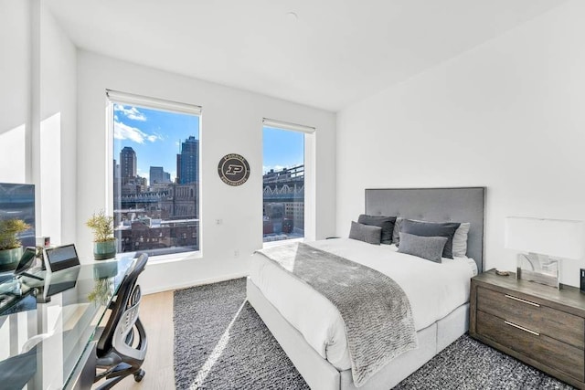 bedroom featuring a city view and wood finished floors