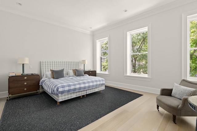 bedroom featuring multiple windows, crown molding, and baseboards