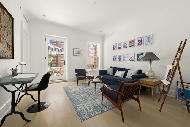 living area featuring baseboards, ornamental molding, and light wood-style floors