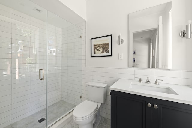 bathroom featuring a stall shower, visible vents, toilet, vanity, and tile walls