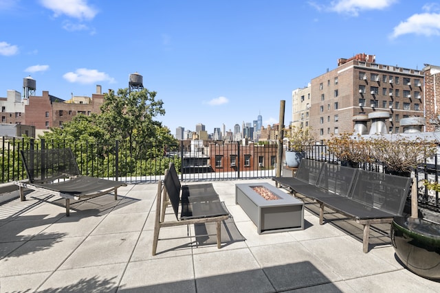 view of patio with an outdoor fire pit and a city view